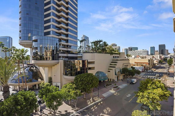 Urban view featuring a tall modern building with glass exteriors, surrounding cityscape visible.