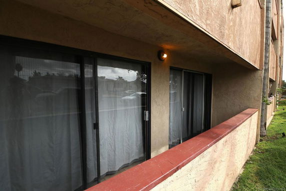 View of a building's exterior with sliding glass doors and a patio area.