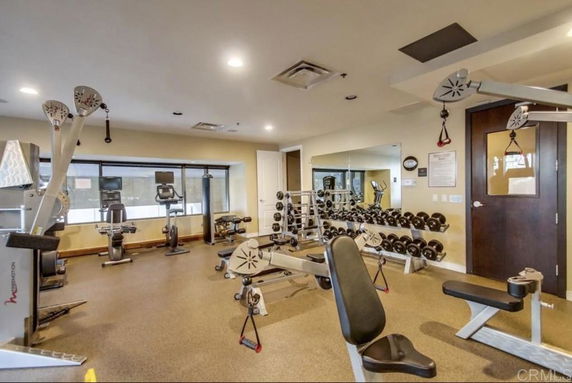 Interior view of a gym with exercise equipment and weights.