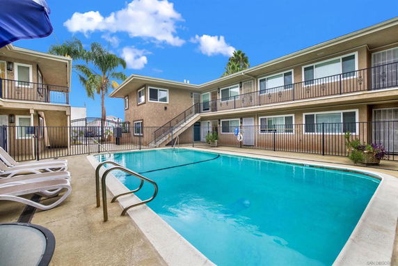 Outdoor swimming pool in the courtyard of a two-story apartment building.