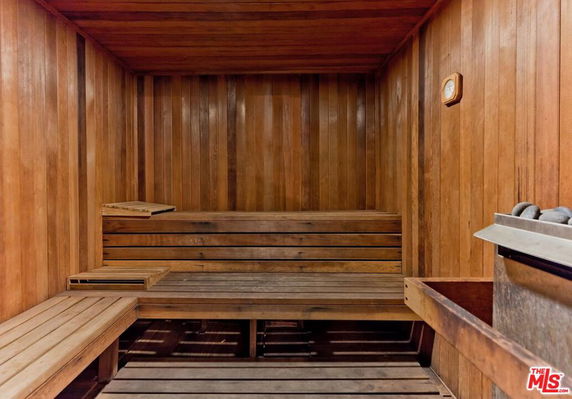 Interior view of a wooden sauna with benches and heating stones.