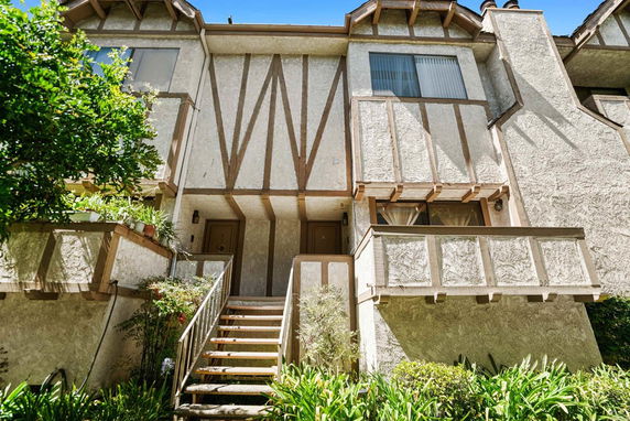Front view of a multi-story building with a staircase leading to the entrance.