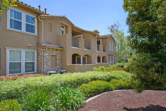 Front view of a two-story house with stone accents and balconies.