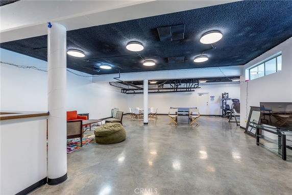 Interior of a clubhouse with seating and fitness equipment.