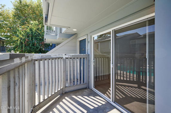 Balcony view with sliding glass door and railing.