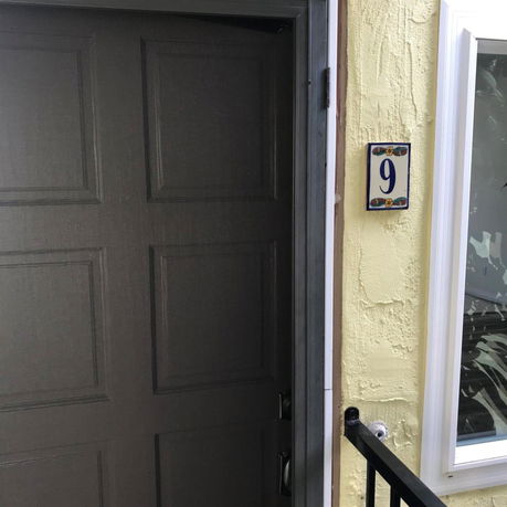 Exterior view of a door with house number 9 on the wall.