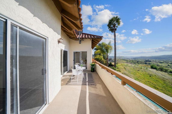 Balcony with outdoor seating and scenic landscape view.
