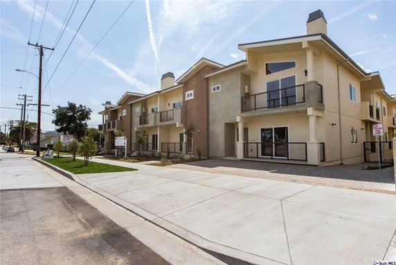Front view of a modern multi-story residential building with balconies.