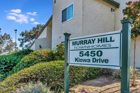 Front view of a townhome building with a visible sign for Murray Hill Townhomes.