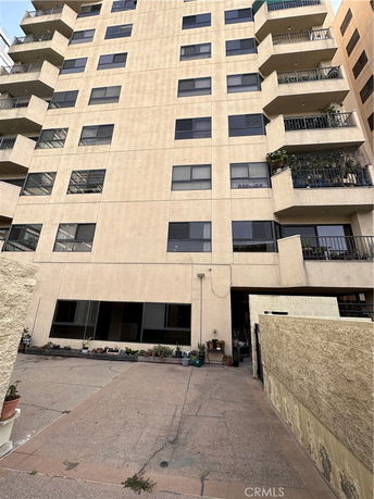 Front view of a multi-story apartment building with balconies.