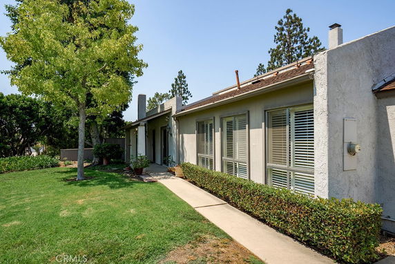 Front view of a single-story house with large windows and a walkway.
