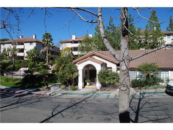 Front view of a multi-story building with arches and tile roof.