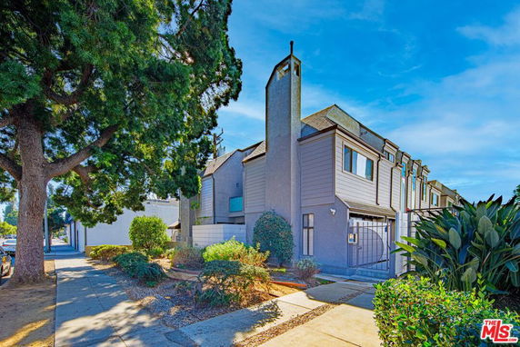 Front view of a multi-story residential building with a gated entrance.