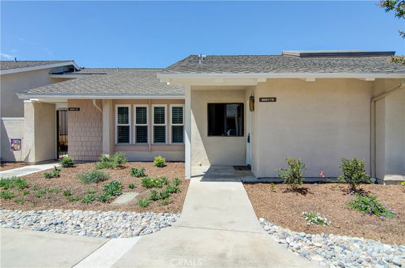 Front view of a single-story house with a small garden and pathway.