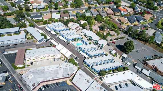 Aerial view of a residential neighborhood with multiple buildings, roads, and parking areas.