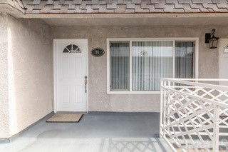 Front view of a house with a white door and a window next to it.