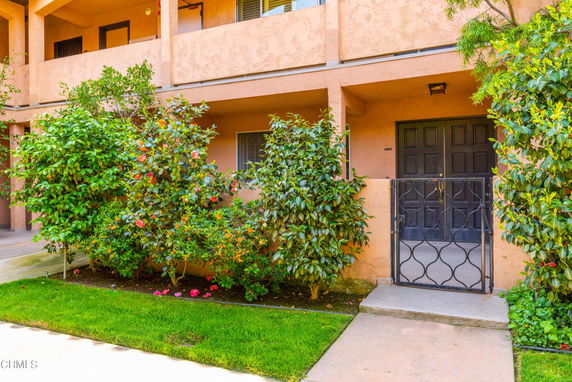 Front view of a multi-story building with a gated entrance.