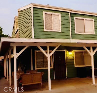 Front view of a two-story house with green siding and a covered porch.