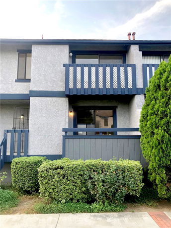 Front view of a two-story house with a small balcony and blue trim.