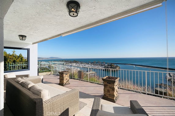 Panoramic view from a balcony overlooking the ocean and a marina.