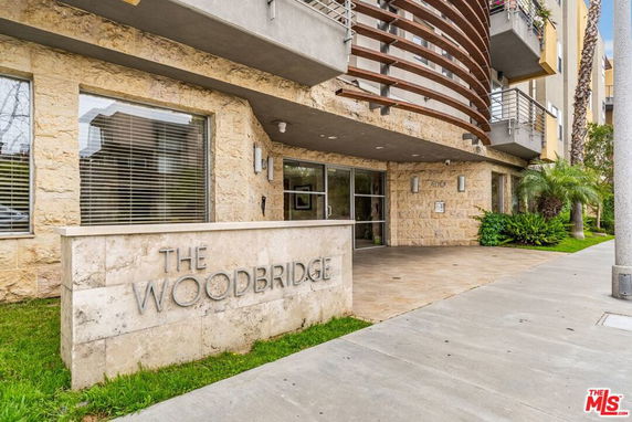 Front view of a building entrance with a sign reading The Woodbridge.