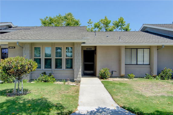 Front view of a single-story house with multiple windows and a central entrance.