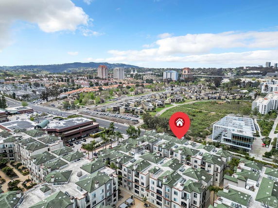 Panoramic view of a residential area with multiple buildings and a city skyline in the background.