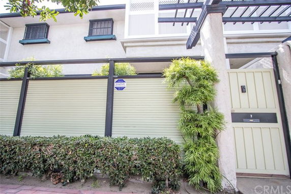 Front view of a two-story building with gates and greenery.