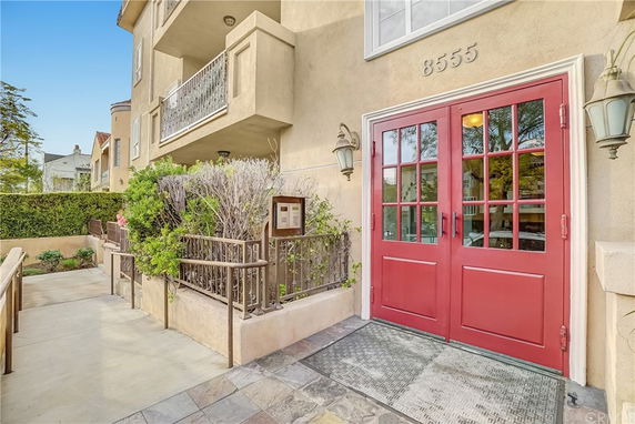 Front view of a building with red double doors and balcony.