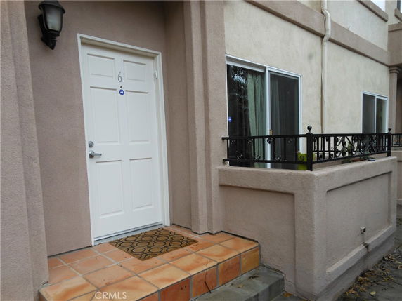 Entrance of a house with a white door and small patio.