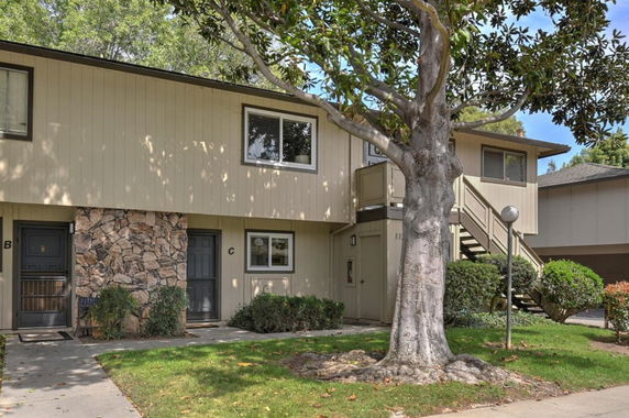 Front view of a two-story residential building with wooden siding and stone accents.