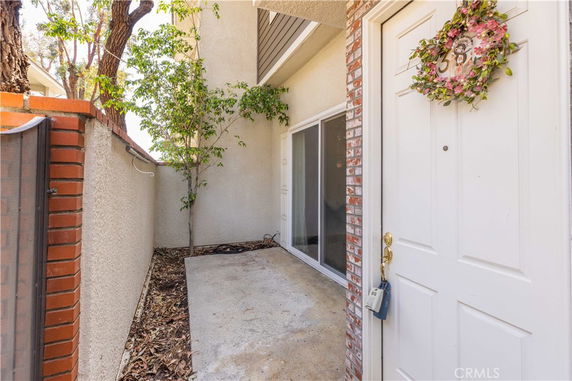 Entryway of a house with a white door and brick siding.