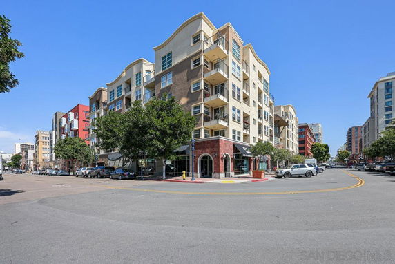 Front view of a multi-story apartment building at the corner of a street.