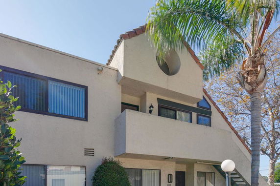 Front view of a house with a distinct A-frame design and balcony.