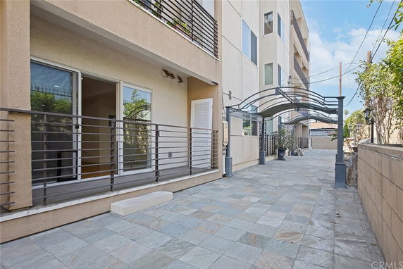 Front view of a multi-story building with balconies and covered walkway.