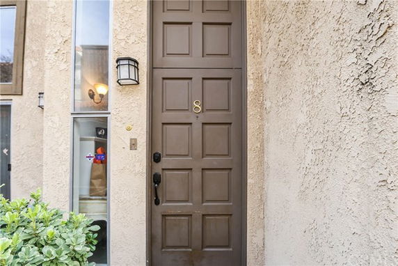 Front view of a house with a brown door and textured exterior walls.