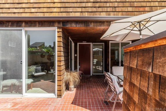 Front view of a house with wooden cladding and sliding glass doors.
