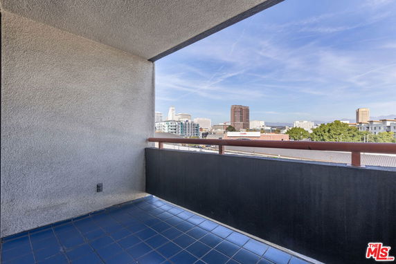 View from a balcony overlooking a cityscape with high-rise buildings.