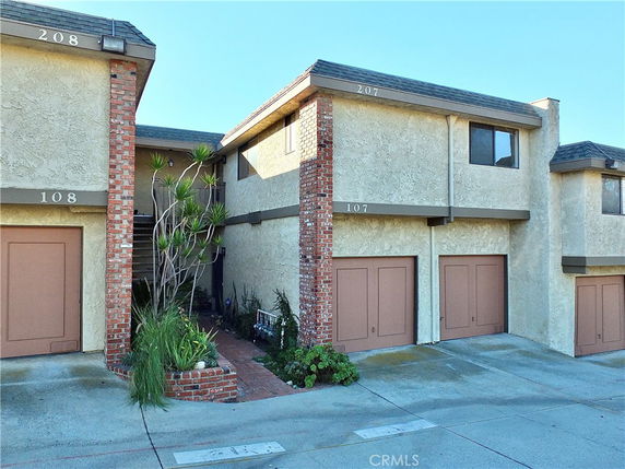 Front view of a multi-story townhouse with attached garage.