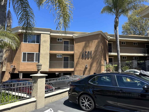 Front view of a multi-story residential building with balconies.