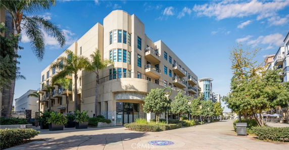 Front view of a modern multi-story apartment building with balconies.