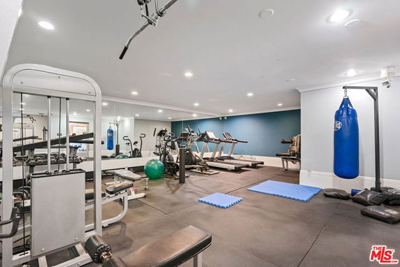 Indoor gym area with various exercise equipment and a punching bag.