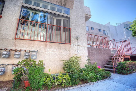 Exterior view of a multi-story building with metal railings and stairs.