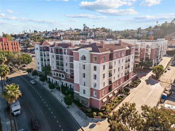 Front view of a multi-story residential building with balconies and decorative architectural details.