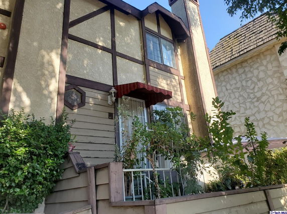 Front view of a two-story house with wood and stucco exterior.