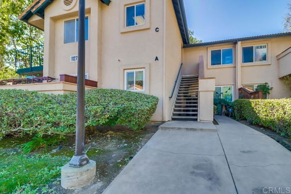 Front view of a two-story residential building with a staircase leading to the upper level.