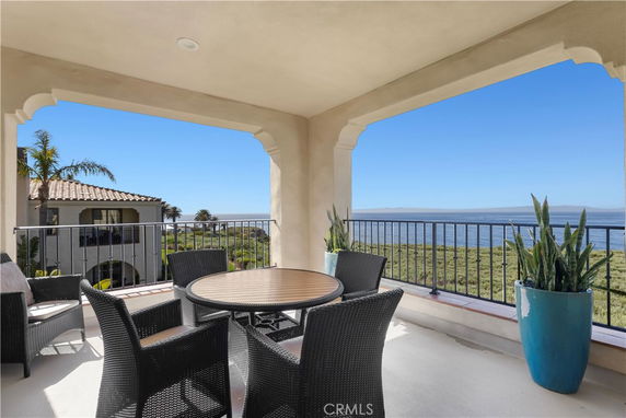 Covered outdoor seating area with ocean in the background.