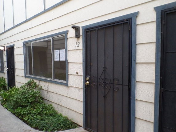 Front view of a house with a metal security door and a window.