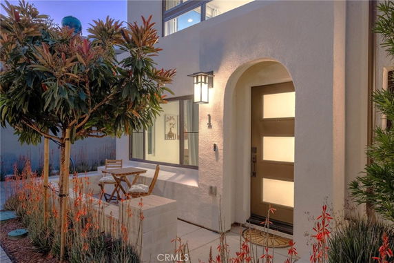 Front view of a modern house entrance with a wooden door and arched entryway.