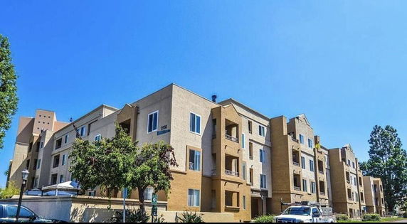 Front view of a multi-story residential building with multiple balconies.